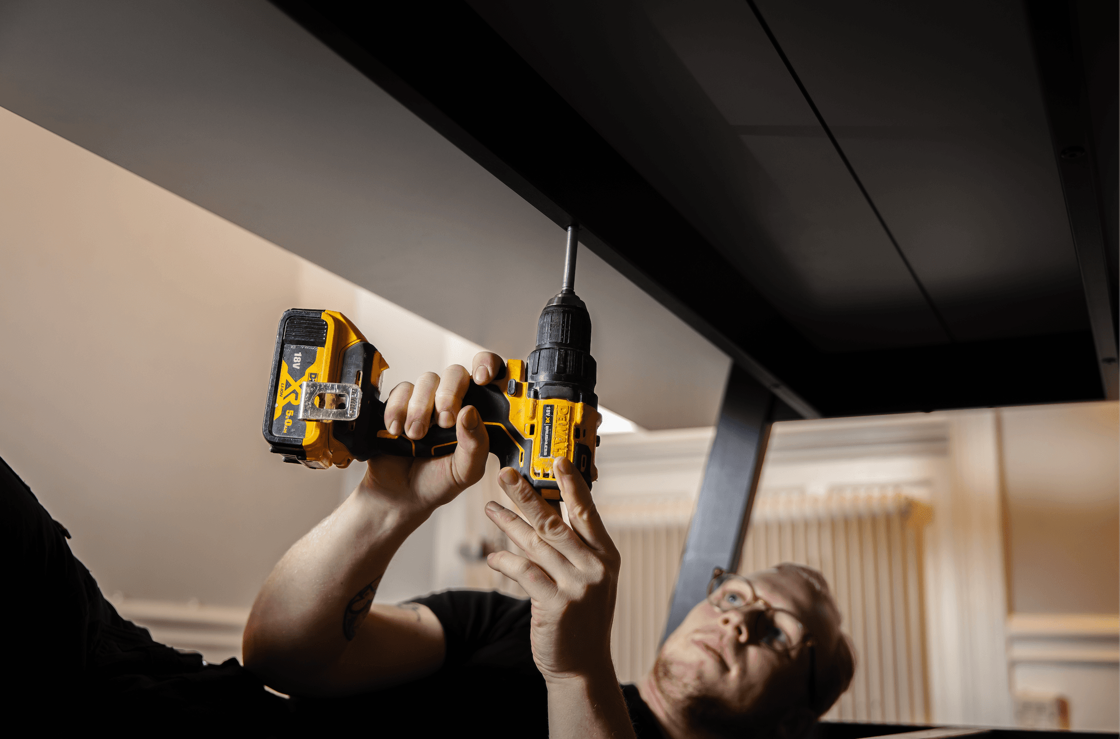 Ungdomskraft worker assembling furniture with a drill — household service qualifying for the RUT tax deduction