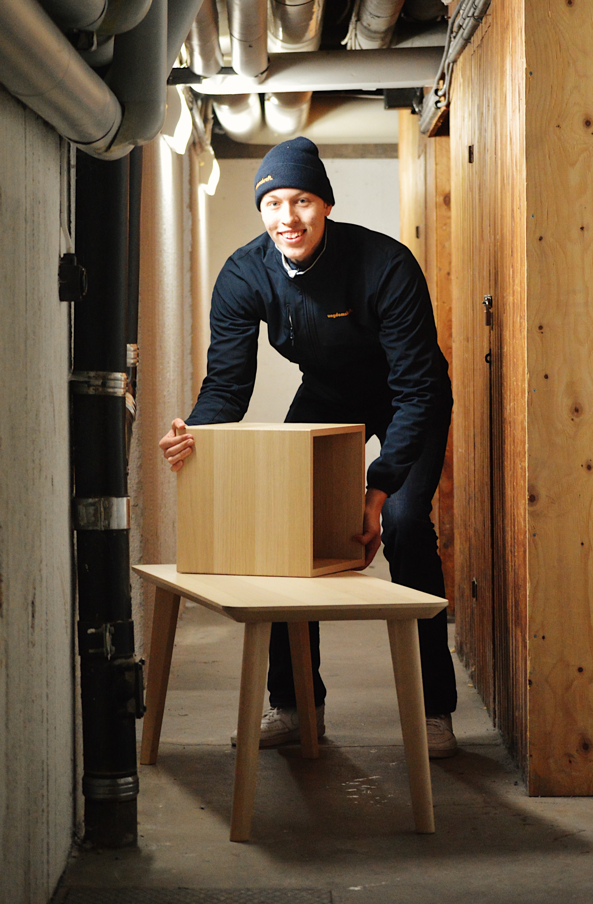 Ungdomskraft-medarbetare bär möbler i källare under ett bortforslingsuppdrag